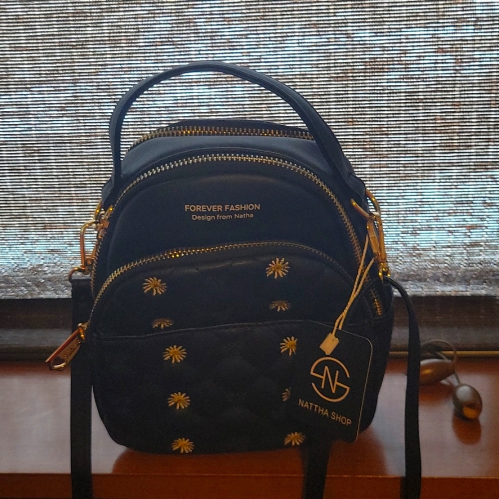 Small fashion back pack. Black in color two compartments.